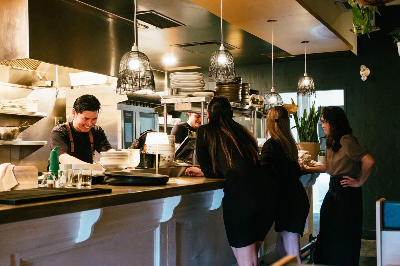 Koks en bediening aan het werk in een gezellige restaurantkeuken